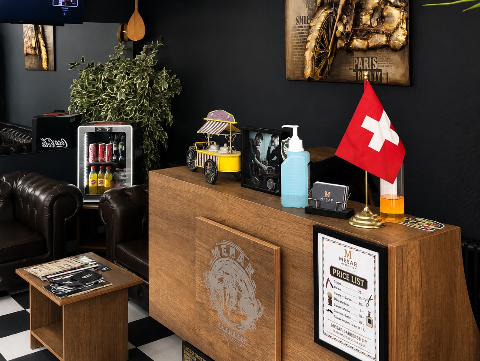 Le comptoir d'accueil en chêne, son drapeau suisse et les fauteuils Chesterfield